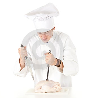 Angry male cook with raw chicken