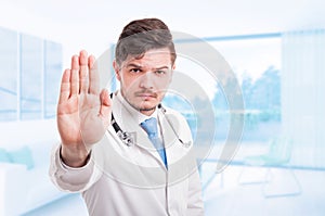 Angry male doctor with repelling gesture