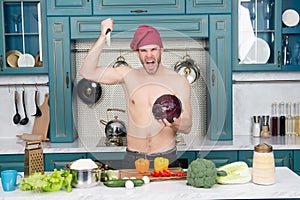 Angry man chef with torso stab knife at cabbage