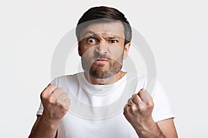 Angry Man Clenching Fists Ready To Fight Over White Background