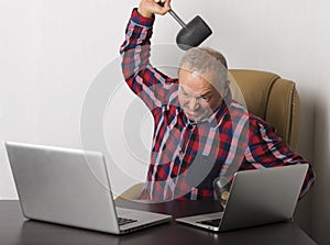 Angry man crashing laptop