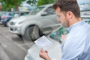 Angry man finding parking ticket fine on his car