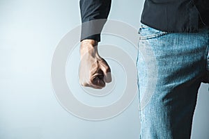 angry man fist on gray wall background.