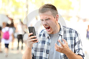 Angry man holding crashed phone photo