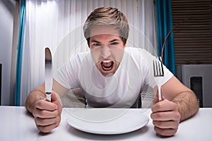 Angry Man Holding Knife And Fork