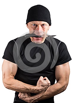 Angry man with knife in his mouth and with his fists