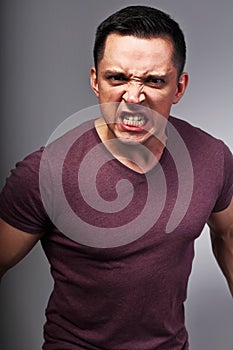 Angry man looking with aggressive eyes and clenched teeth. Closeup