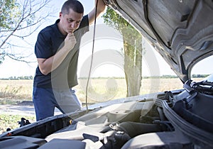 An angry man looks at the idle car engine. The driver tries to explain the cause of the breakdown to the mechanic using his