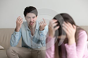 Angry man mad at girlfriend, shouting at her, couple quarrelling