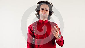 Angry man in a red shirt persuade someone with a hand gesture posing against a white background
