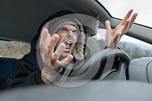 Angry man with screaming into car in winter time