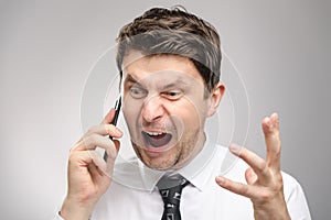 Angry man screaming on client by phone. Aggressive boss calling employee who didn`t finish his work on time.