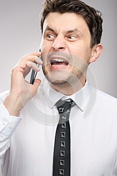 Angry man screaming on client by phone. Aggressive boss calling employee who didn`t finish his work on time.