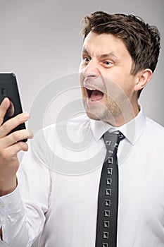 Angry man screaming on client by phone. Aggressive boss calling employee who didn`t finish his work on time.