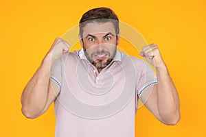 Angry man screaming. Portrait of young angry man isolated on yellow background. Angry male face. Guy with nervous crisis