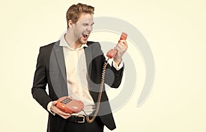 Angry man shout in vintage telephone receiver holding old-fashioned landline phone, telephony