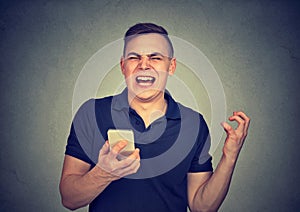 Angry man shouting at his cell phone, enraged with the bad service poor quality of smartphone