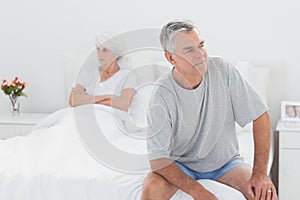 Angry man sitting in bed during a dispute