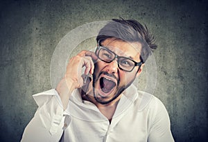 Angry man speaking on phone and yelling