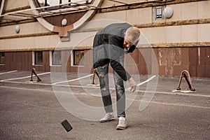 Angry man is throwing away his mobile phone