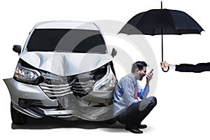 Angry man with umbrella and broken car