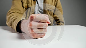 Angry man worker hits table with fist sitting in office