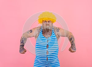 Angry man with yellow wig and swimsuit is ready to the summer