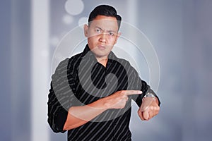 Angry manager businessman while pointing his watch showing time