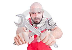 Angry mechanic or plumber holding crossed wrenches