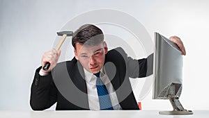 Angry men holding hammer over PC monitor