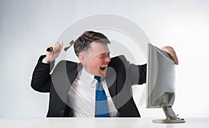 Angry men holding hammer over PC monitor