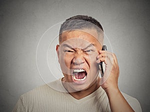 Angry middle aged man off employee shouting while on phone