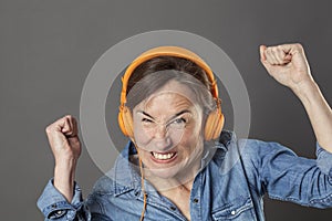 Angry middle aged woman frowning listening to noise or music