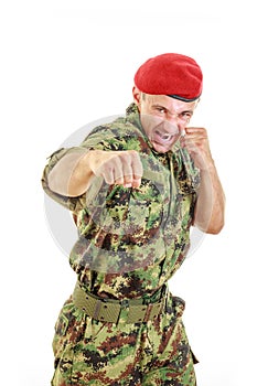 Angry military soldier in uniform and cap hitting with fist