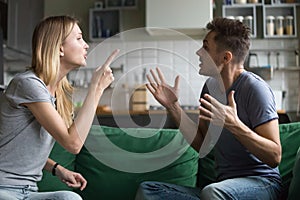 Angry millennial couple arguing shouting blaming each other of p