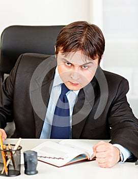 Angry modern businessman banging fist on table photo