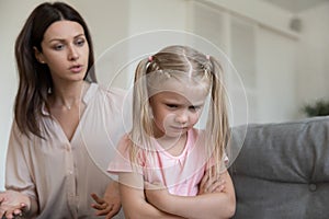 Angry mom scolding stubborn fussy upset little kid daughter photo