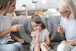 Angry mother and grandmother scolding lecturing upset kid girl t