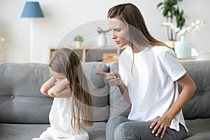 Angry mother scolding stubborn kid closing ears not listening photo