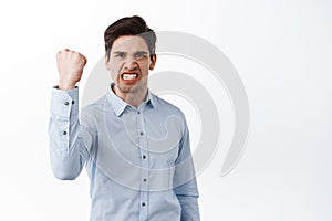 Angry office worker shaking fist in threaten, look outraged and pissed-off, standing frustrated against white background