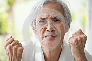 Angry old elderly clenching fists,furious expression on face,showing displeasure,hostility,bad-tempered,feeling irritation, photo