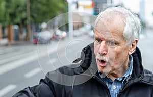 Angry old man shouting on a street canyon.