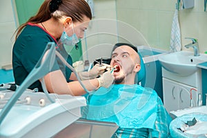 Angry patient with dentis in dental office checks teeth