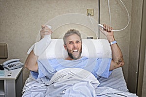 Angry patient man at hospital room lying in bed pressing nurse call button holding potty