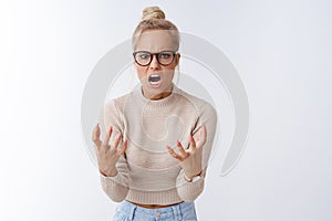 Angry pissed woman shouting with scorn and hate at camera squeezing fists anger frowning acting furious and crazy