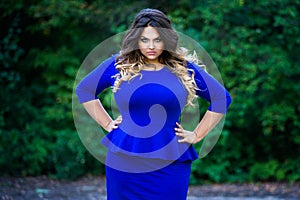 Angry plus size fashion model in blue dress outdoors, beauty woman with professional makeup and hairstyle