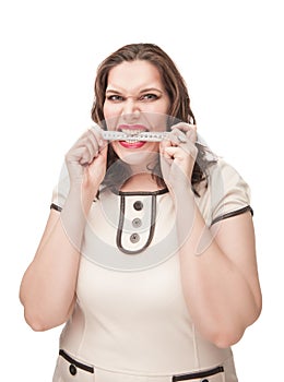 Angry plus size woman gnawing centimeter photo