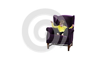 Angry red hair child sitting on the purple armchair