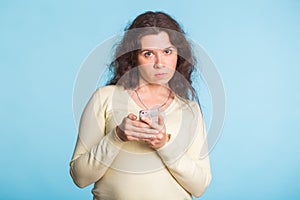 Angry and resentful woman waiting for excuses and explanations and is reproachfully looking on blue background.