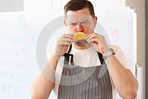 Angry sad male cook with orange slice frown